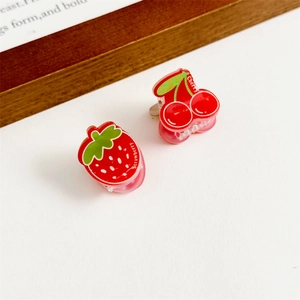 Gros plan détaillé sur des pinces à cheveux en acrylique fraise et cerise pour filles