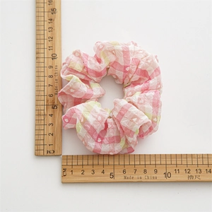Chouchou à carreaux rose et blanc avec motifs de cœurs montrant la taille sur règle