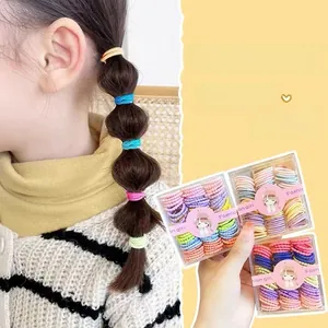 Gros plan d'élastiques à cheveux colorés en boîte pour enfants avec modèle de coiffure