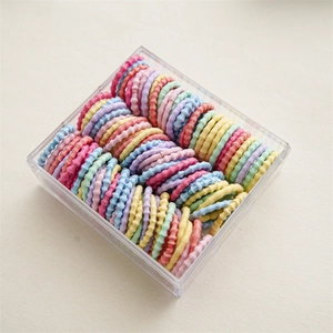 Détail d'élastiques à cheveux colorés en boîte de rangement carrée transparente