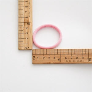 Vista de detalle de goma de pelo rosa sin costuras con medida de 4 cm de diámetro