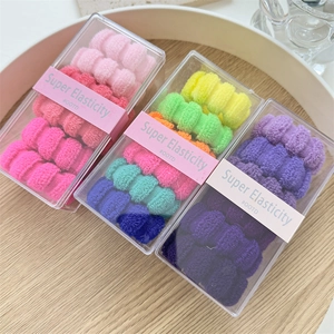 Close-up of high elasticity colorful hair bands in transparent boxes with OOTD label