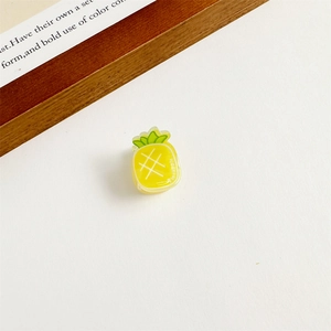 Gros plan d'une jolie pince à cheveux ananas jaune avec un sommet vert pour filles