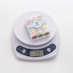Coffret d'élastiques à cheveux macarons pour enfants pesant 39,7g sur une balance