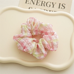 Détail d'un chouchou en seersucker à carreaux rose et vert avec texture douce