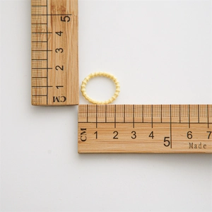 Gros plan d'un élastique à cheveux jaune montrant un diamètre de 1,8 cm sur une règle