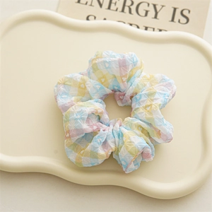 Vue détaillée d'un chouchou à carreaux colorés avec motifs de cœurs et tissu gaufré