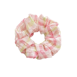Chouchou à carreaux rose et jaune avec motifs de cœurs blancs et texture de tissu plissé