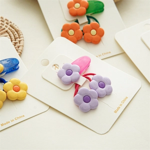 Détail de pinces à cheveux et élastiques fleurs de frangipanier aux tons macaron