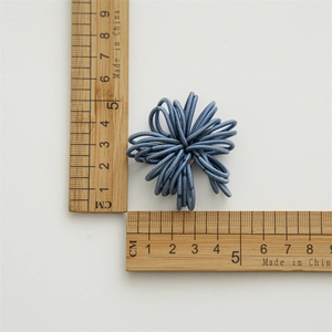 Macro view of blue high-elasticity hair ties with measurement ruler for size reference