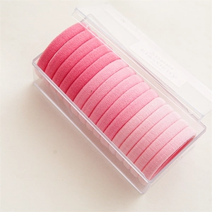 Vista macro de 20 gomas elásticas para el pelo rosa degradado en caja transparente