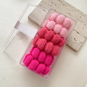 Close-up of pink high-elasticity seamless towel hair ties set in a clear storage box