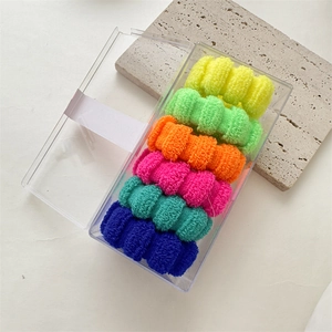 Close-up of six colorful seamless high-elastic hair ties in a transparent storage box