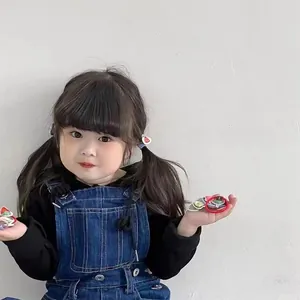 Detail of cute cartoon fruit hair clips and elastic bands worn by a young girl model