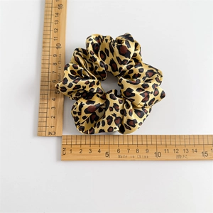 Leopard print satin hair scrunchie measuring approximately 11cm on white background