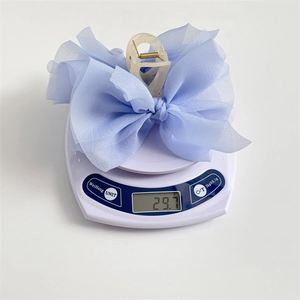 Grande molletta per capelli con fiocco in chiffon azzurro e base in resina sulla bilancia