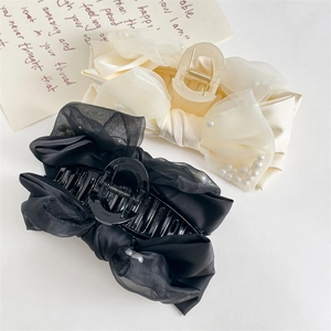 Detail of large black and cream organza bow shark clips with pearl embellishments