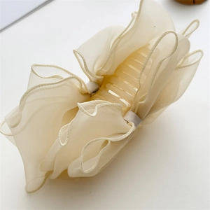 Détail d'une pince à cheveux en organza crème pour un coiffage élégant des cheveux longs