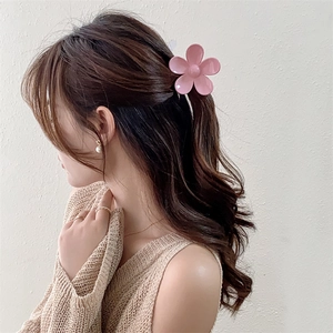 Dettaglio di una molletta per capelli a forma di fiore rosa opaco su una modella