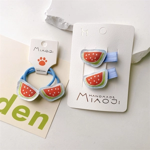 Detailed view of handmade embroidered watermelon hair clips and tie set for kids