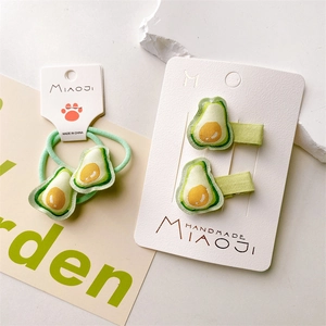 Detail of handmade avocado embroidery hair clip and hair tie set for girls
