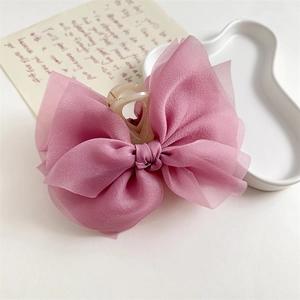Dettaglio molletta per capelli con fiocco in organza rosa e finitura multistrato