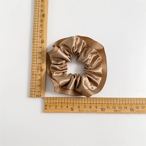 Champagne satin ruffled hair scrunchie with 10cm diameter measurement on white background
