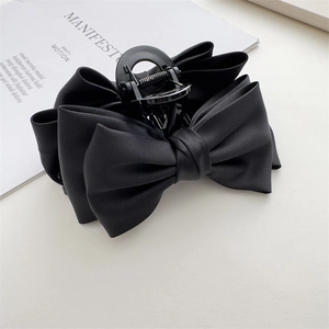 Elegant large black satin double bow shark hair claw clip for women on minimalist background