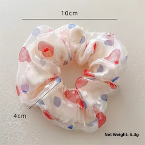 Dettaglio dell'elastico per capelli in rete a pois bianchi con diametro di 10 cm