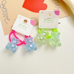 Detailed macro view of cute acrylic jelly bear hair ties on white brand display cards