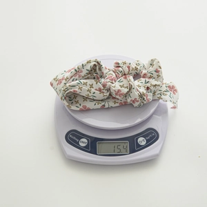 Floral print fabric scrunchie with bow tie in cream white, weighing 15.4g on scale