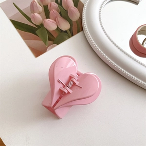 Dettaglio di un fermaglio per capelli rosa a forma di cuore con finitura lucida
