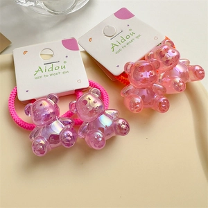 Macro view of iridescent pink acrylic bear charms on elastic hair ties for girls