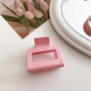 Dettaglio molletta per capelli in resina rosa crema opaca con design rettangolare cavo