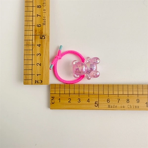 Pink elastic hair tie with translucent purple gummy bear charm and measurement scale
