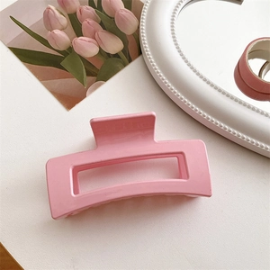 Dettaglio della grande pinza per capelli quadrata in resina rosa con design geometrico