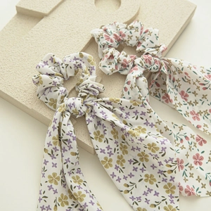 Detailed close-up of floral print hair scrunchies with long bows on stone decor