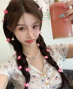 Gros plan de barrettes à cheveux roses en forme de cœur avec des bijoux en perles