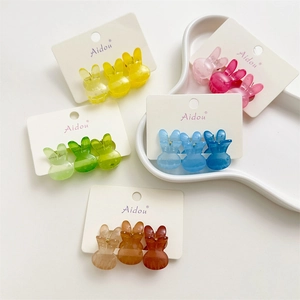 Détail de mini pinces à cheveux lapin colorées dans diverses teintes acidulées