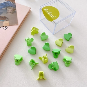 Gros plan de mini pinces à cheveux en forme de cœur avec dégradé vert mat sur fond blanc