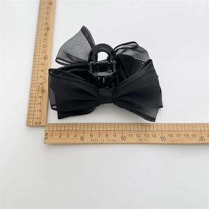 Detailed view showing the 14cm width of this black bow hair claw clip with rulers