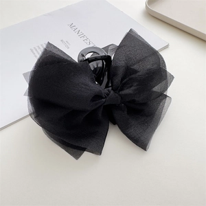 Macro shot of black oversized organza bow hair claw clip with delicate mesh textures