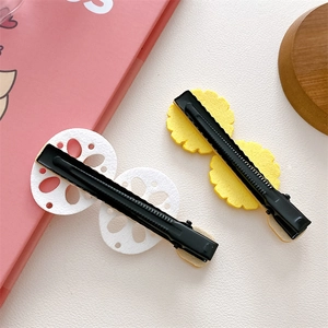 Detail view of cute felt lotus and flower hair clips on black metal duckbill clips