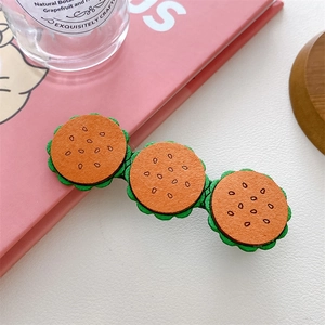 Detailed close-up of cute cartoon hamburger snack hair clips with a soft leather texture