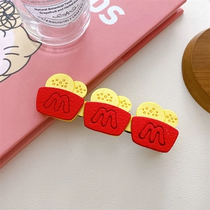 Close-up of cute cartoon snack hair clip with red French fries design and M logo