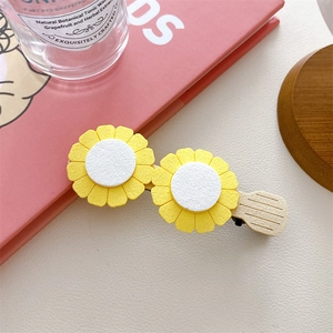 Close-up of yellow and white double flower hair clip with a beige matte duckbill clip