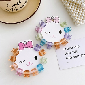 Close-up of colorful mini flower hair claws with glitter on cat-shaped display cards