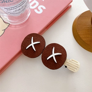 Detail of funny food-shaped hair clip showing cute grilled mushroom design on black duckbill clip