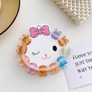 Close-up of mini glitter hair claws in macaron colors on a cute rabbit display card
