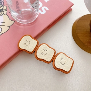 Close-up of three cute cartoon toast clips with smiling faces on a pink background